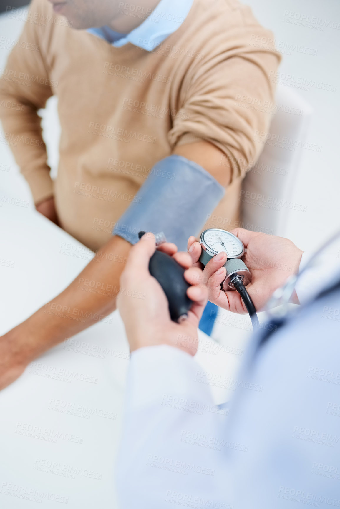 Buy stock photo High angle shot of a male doctor taking a patient's blood pressure