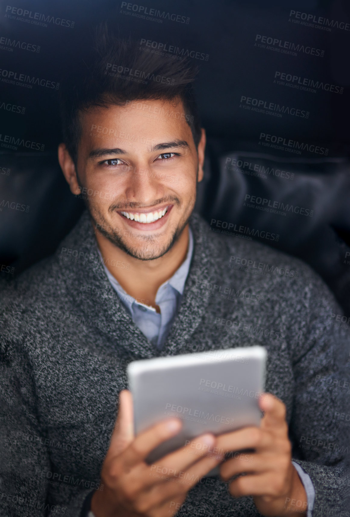 Buy stock photo Portrait of a smiling young man using a digital tablet in the dark