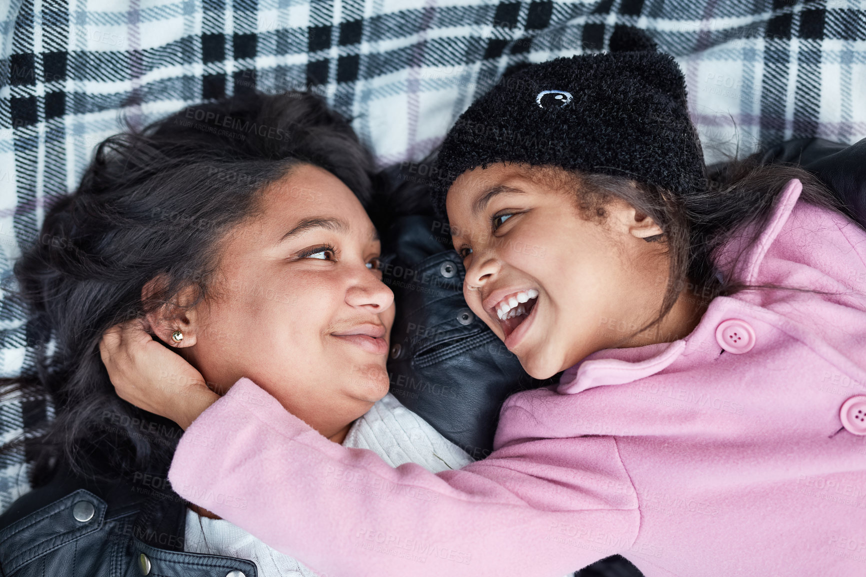 Buy stock photo Cropped shot of a little girl and her mother bonding while lying on a blanket outside together