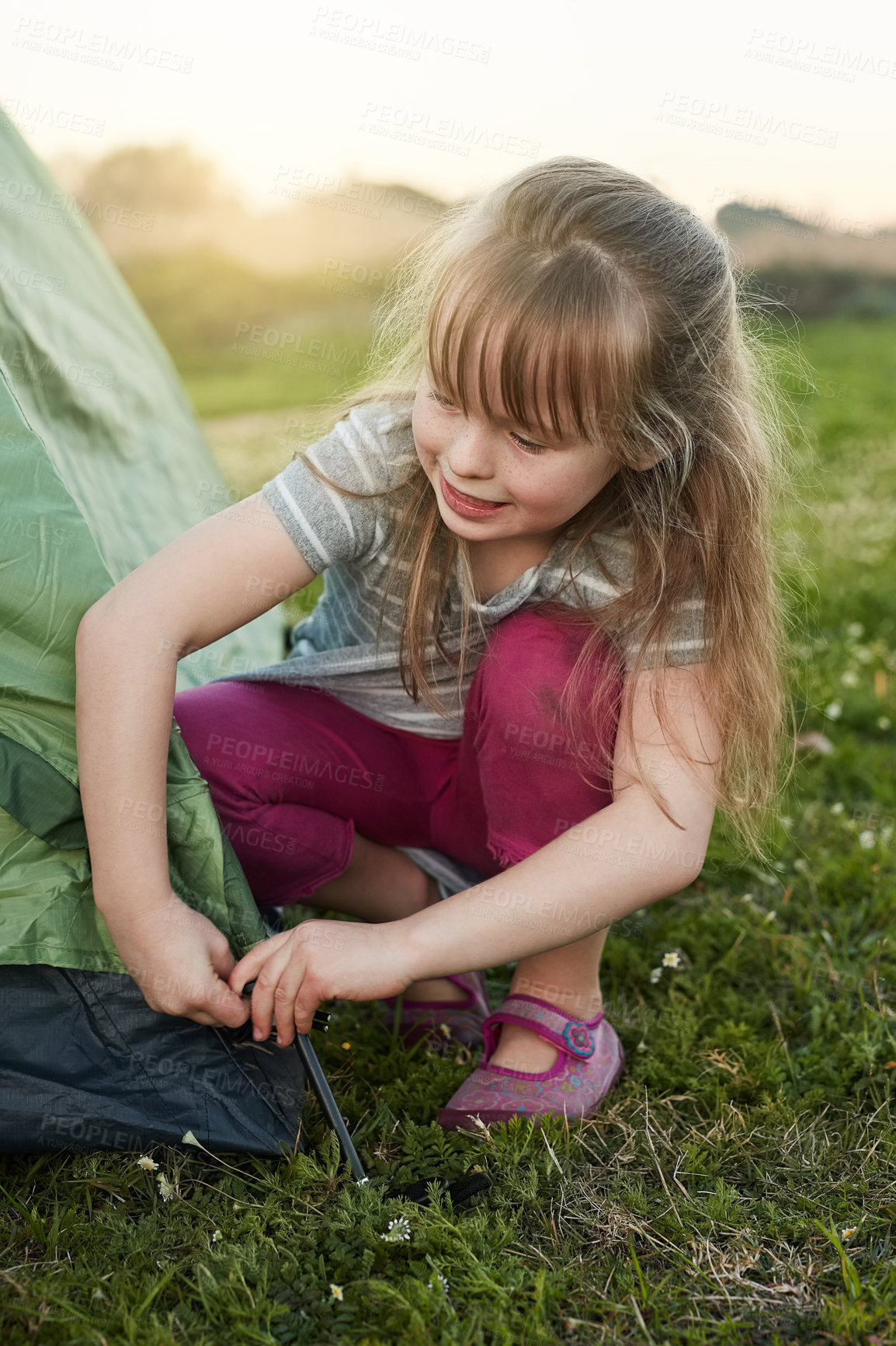 Buy stock photo Cropped shot of a little girl putting up a tent by herself