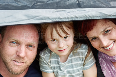 Buy stock photo Portrait of a cute little girl and her parents sitting inside a tent together