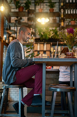 Buy stock photo Shot of a young man working on his laptop in a coffee shop