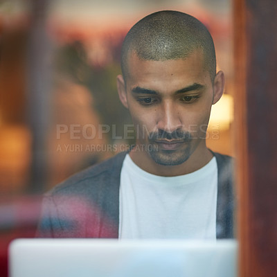 Buy stock photo Cropped shot of a young man working on his laptop in a coffee shop