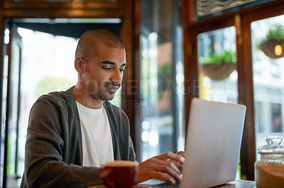 Buy stock photo Cropped shot of a young man working on his laptop in a cafe