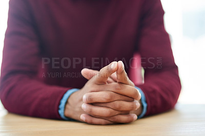 Buy stock photo Shot of an unidentifiable businessman sitting with his hands folded in the office