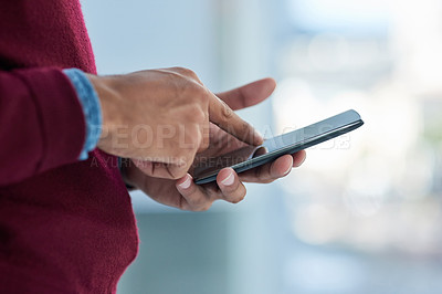 Buy stock photo Shot of an unidentifiable businessman using his smartphone in the office
