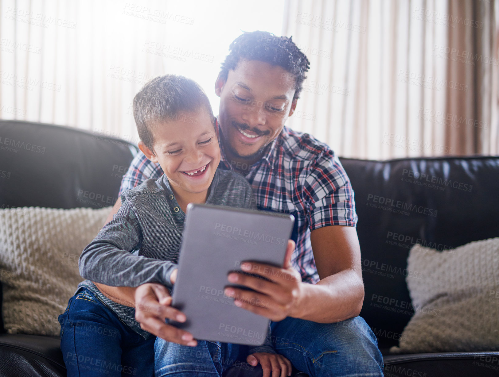 Buy stock photo Cropped shot of a father and son using a digital tablet at home