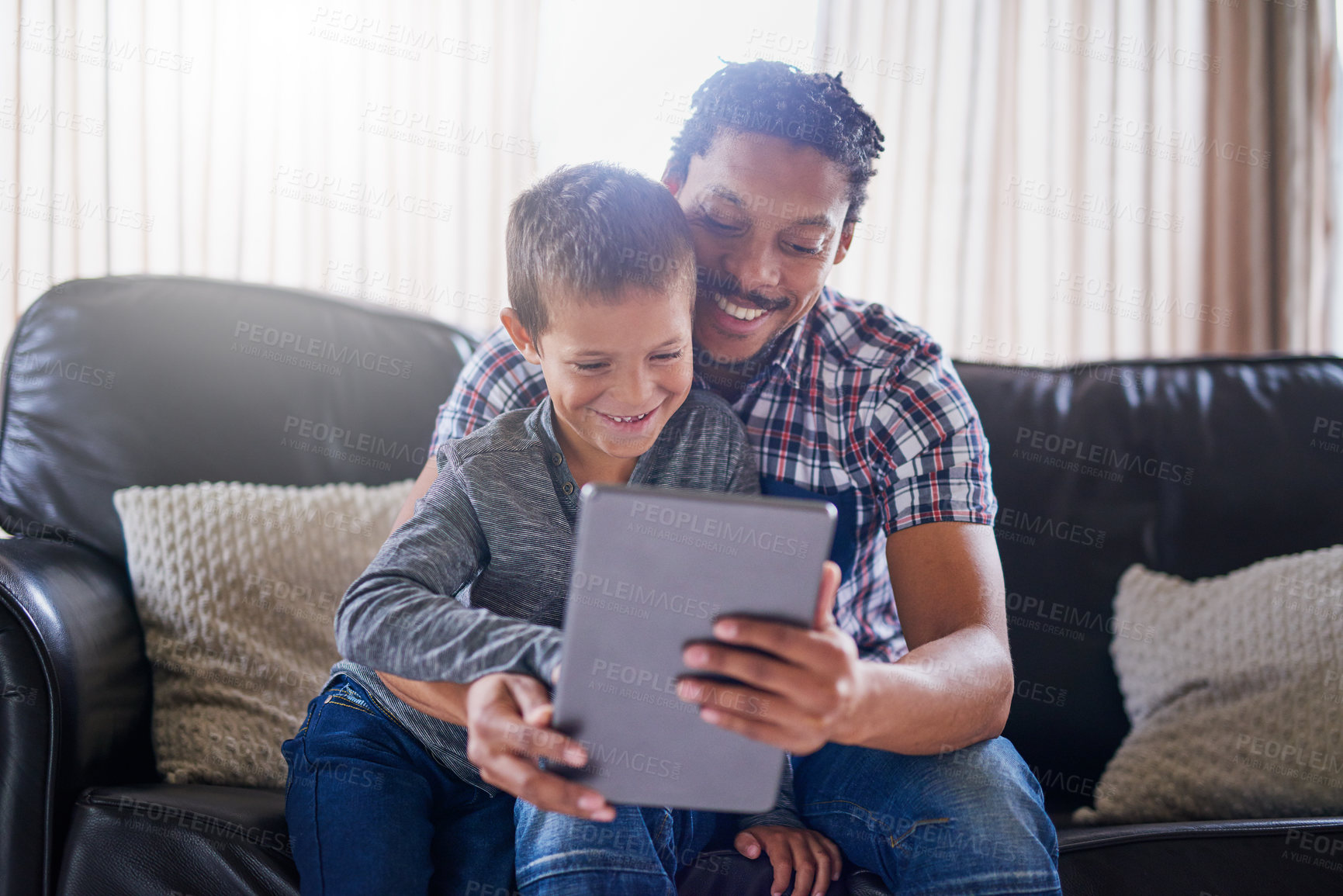 Buy stock photo Cropped shot of a father and son using a digital tablet at home