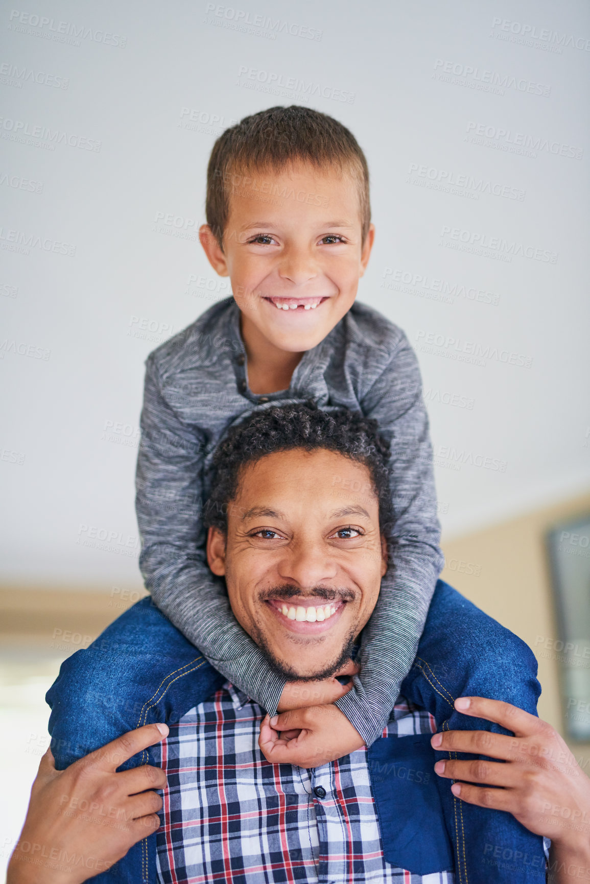 Buy stock photo Portrait of a father carrying his son on his shoulders at home