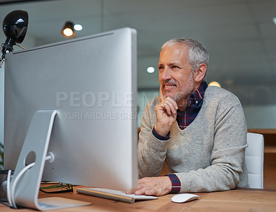 Buy stock photo Shot of a smiling mature businessman working on a computer in an office