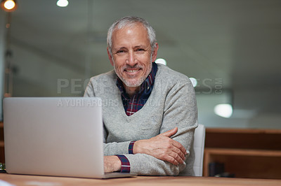Buy stock photo Portrait of a smiling mature businessman using a laptop while working in an office