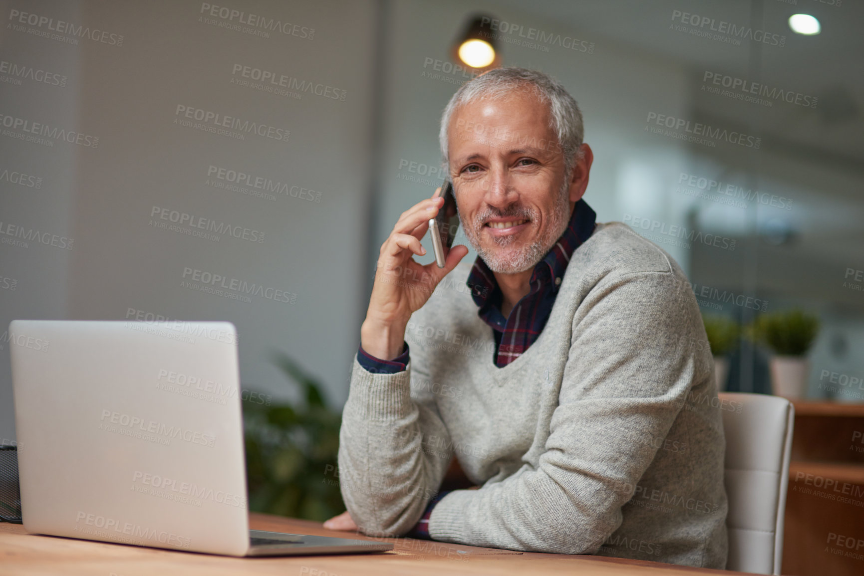 Buy stock photo Portrait of a mature businessman talking on a cellphone while working in an office