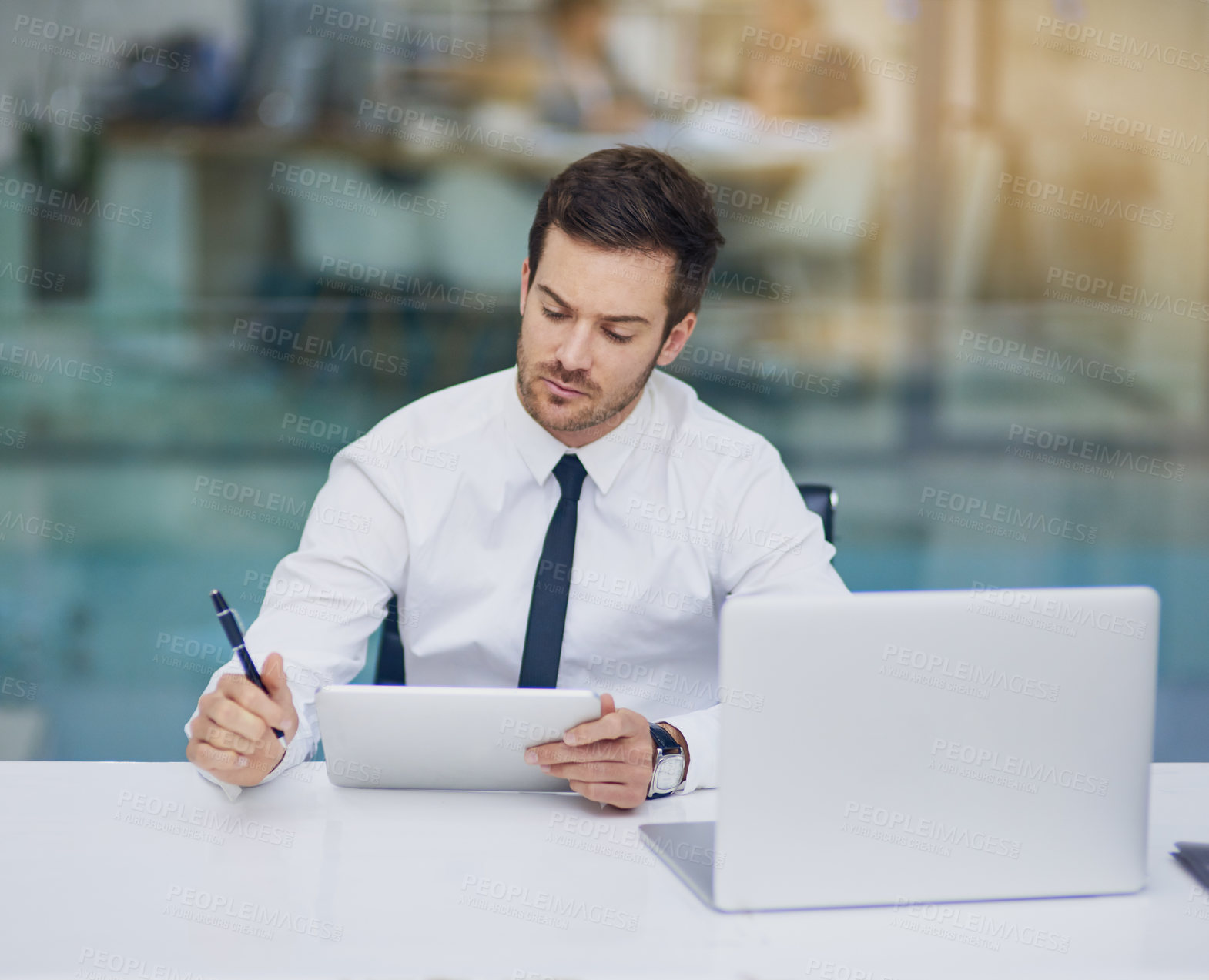 Buy stock photo Shot of a young businessman working in his office