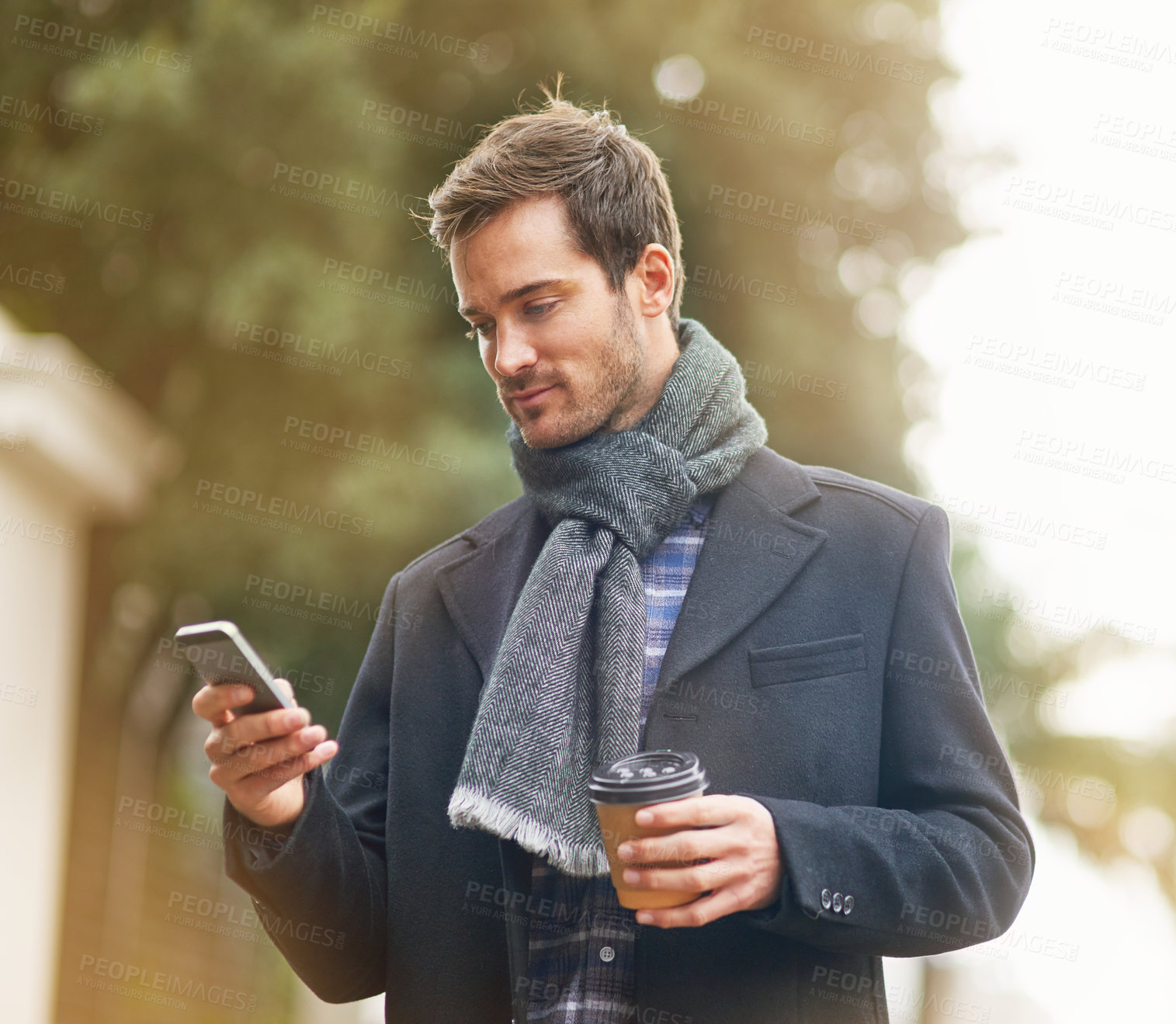 Buy stock photo Shot of a young man using his phone outside