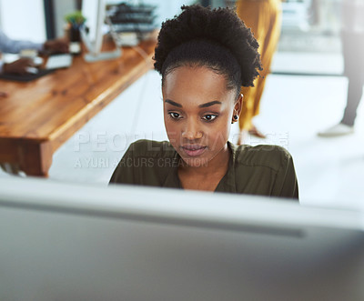 Buy stock photo Cropped shot of a young businesswoman working on a computer in a modern office