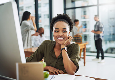 Buy stock photo Portrait of a young businesswoman sitting at her desk with colleagues in the background