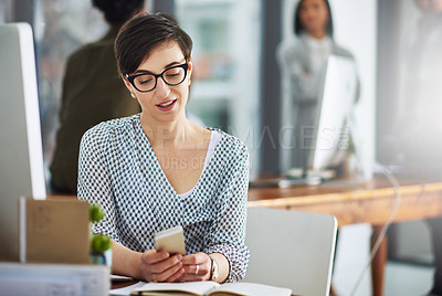 Buy stock photo Cropped shot of a young businesswoman texting on a cellphone in an office