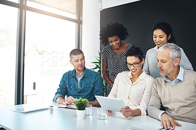Buy stock photo Shot of a group of coworkers talking together over a digital tablet in a boardroom