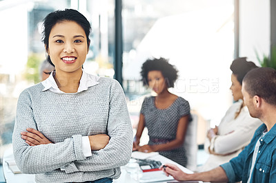 Buy stock photo Portrait of a smiling businesswoman standing in a boardroom with colleagues in  the background