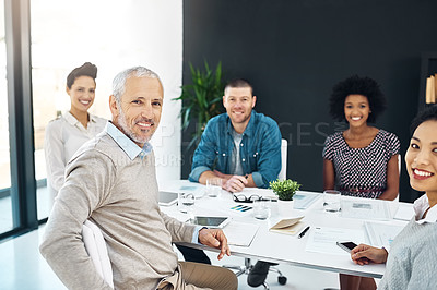 Buy stock photo Portrait of a group of smiling colleagues sitting together in a boardroom