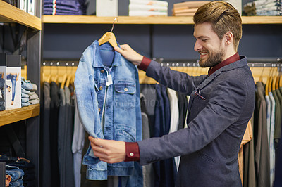 Buy stock photo Shot of a young man looking at clothes in a boutique