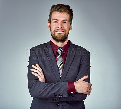 Buy stock photo Studio portrait of a handsome young businessman posing confidently against a gray background