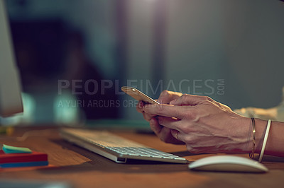 Buy stock photo Closeup shot of a businesswoman using her cellphone while working late in an office