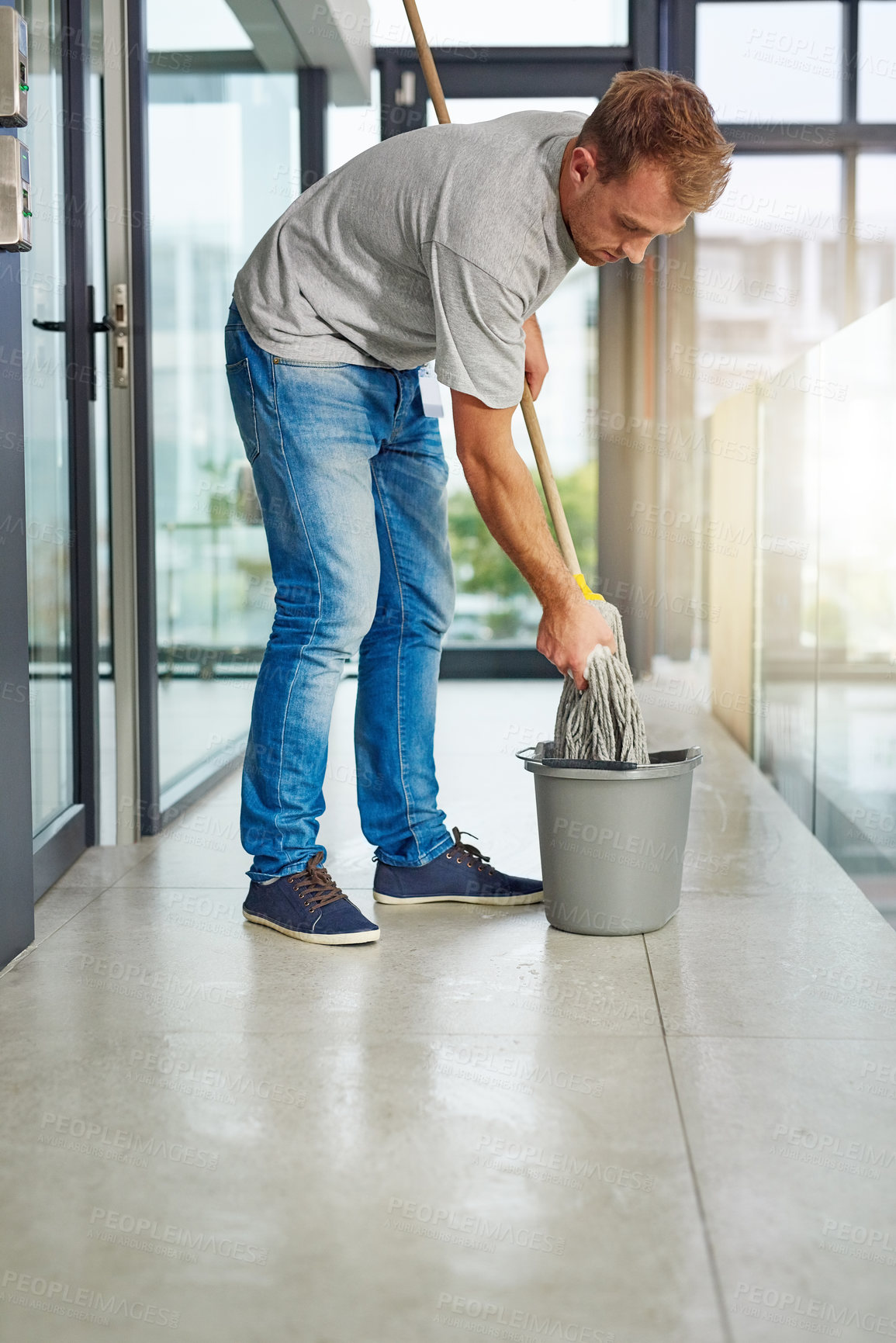 Buy stock photo Janitor, mop or cleaning floor in office for housekeeping, building maintenance and hygiene services. Bucket, hospitality professional or caretaker in workplace for health, maintenance or bacteria