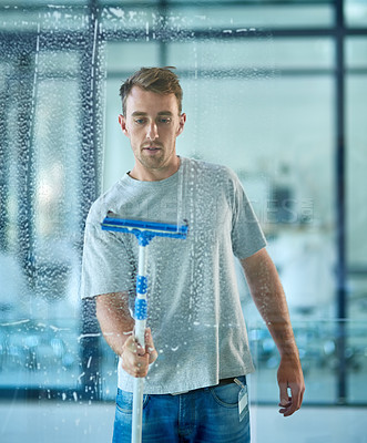 Buy stock photo Man, cleaning and window in office building as janitor with squeegee tool for hygiene service, glass or bacteria. Male person, soap and disinfection in corporate workplace or washing, dust or germs