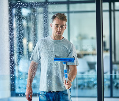 Buy stock photo Man, cleaning and window in office building or service with squeegee tool for hygiene, glass or bacteria. Male person, janitor and disinfection soap in corporate workplace or washing, dust or germs