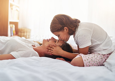 Buy stock photo Kiss mother, girl and relax on bed for love, care and quality time to bond at home. Single mom, daughter and affection in bedroom for security, mothers day and support in living space for family
