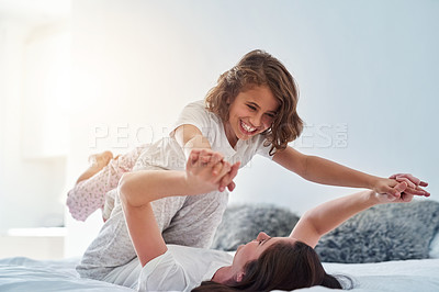 Buy stock photo Shot of a mother and daughter having fun together at home in the morning