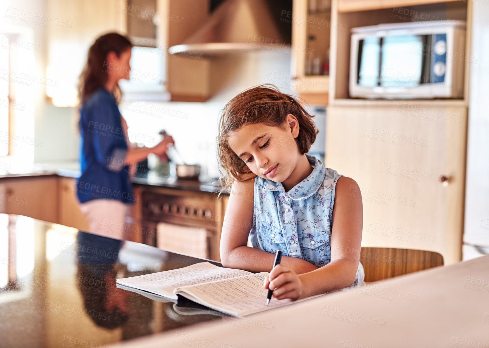 Buy stock photo Cropped shot of a young girl writing in a book while her mom cooks in the background