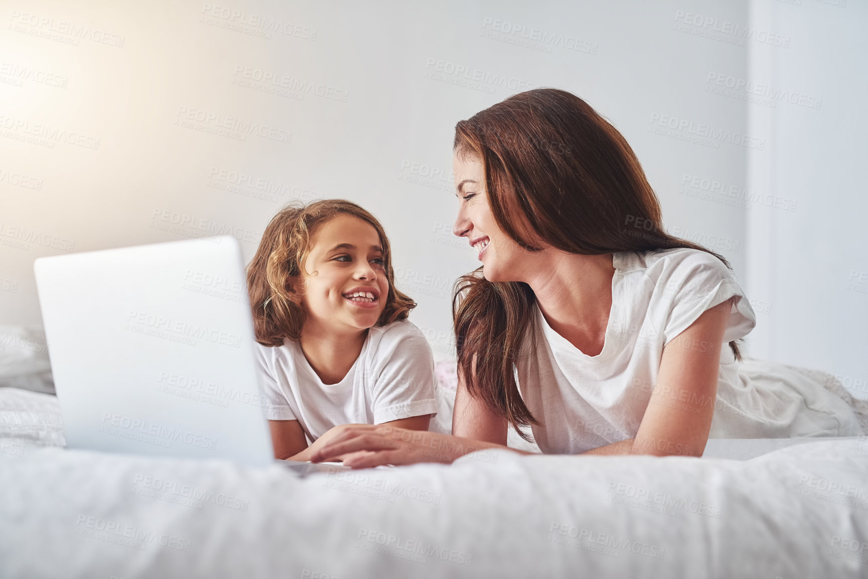 Buy stock photo Mother, child and laptop on bed in bedroom for fun, streaming and online game at home. Woman, daughter and happy while relaxed for comedy, joke and funny video while watching together for bonding