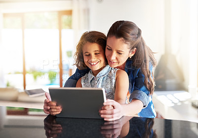Buy stock photo Cropped shot of a mother and daughter using a digital tablet at home