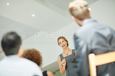 Buy stock photo Shot of a businesswoman holding a digital tablet while giving a presentation to colleagues in a modern office