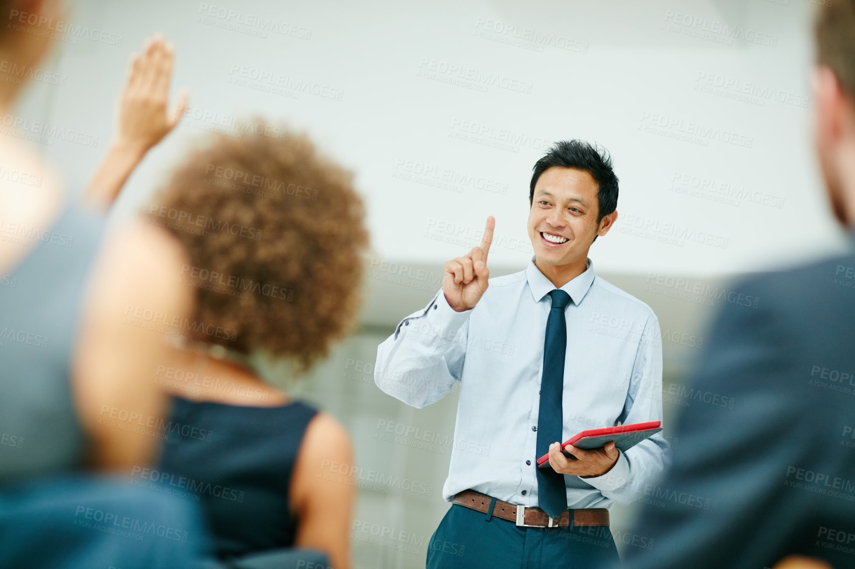 Buy stock photo Shot of a businessman holding a digital tablet while giving a presentation to colleagues in a modern office