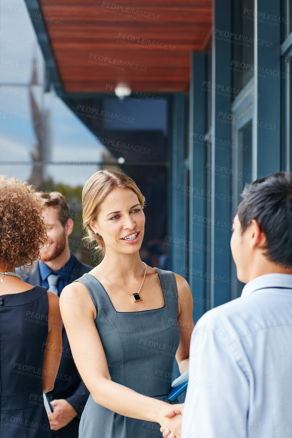 Buy stock photo Shot of a businesswoman and businessman shaking hands outdoors