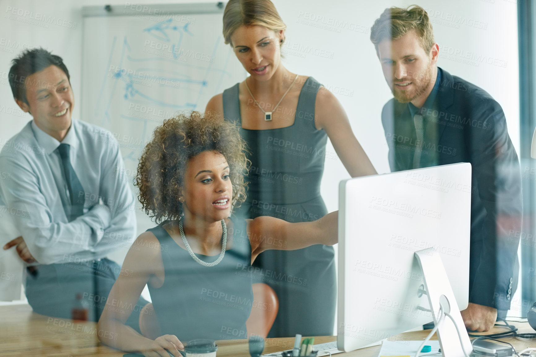 Buy stock photo Shot of a group of businesspeople discussing something on a computer