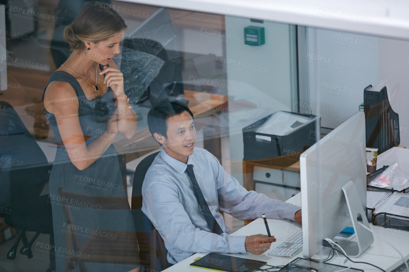 Buy stock photo Shot of two colleagues working together on a computer