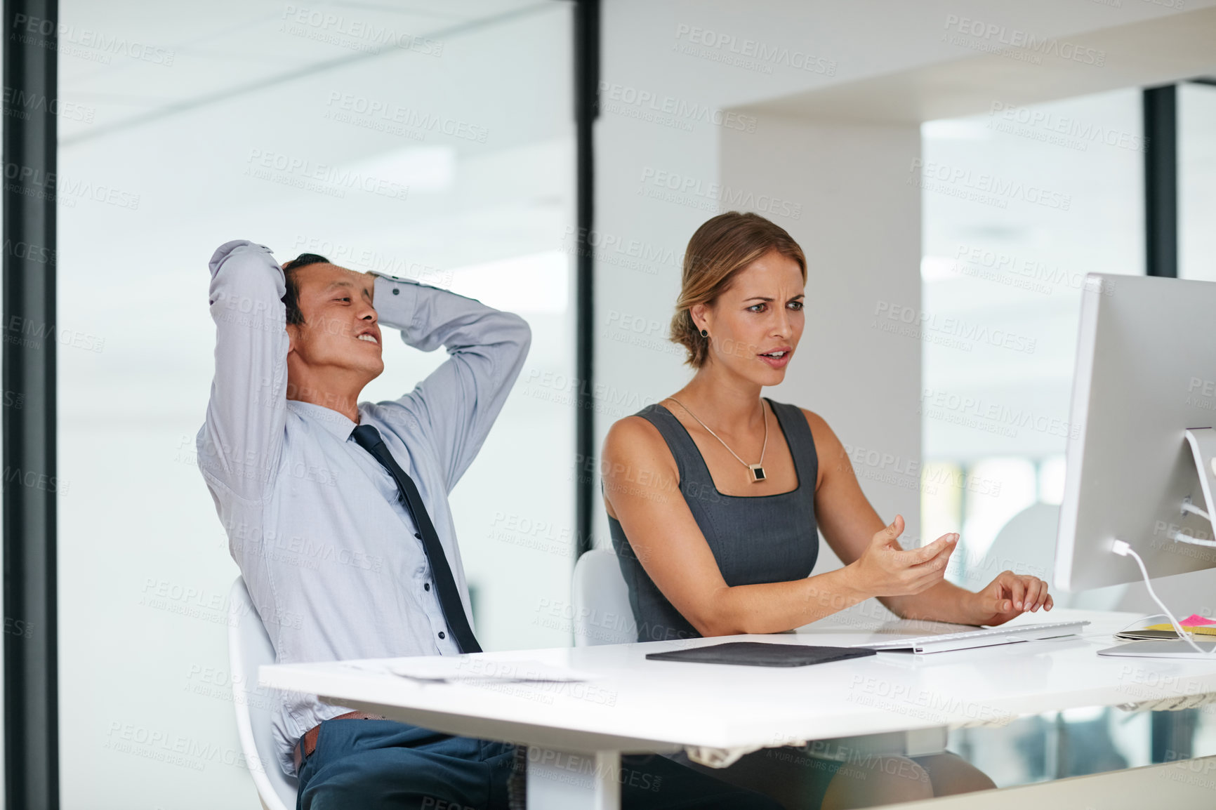 Buy stock photo Shot of two colleagues working together on a computer