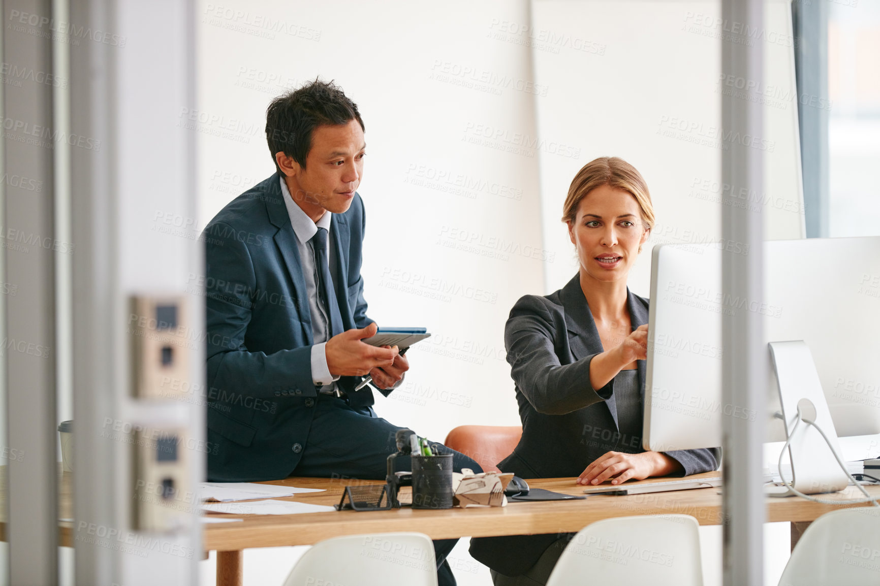 Buy stock photo Shot of two colleagues working together on a computer