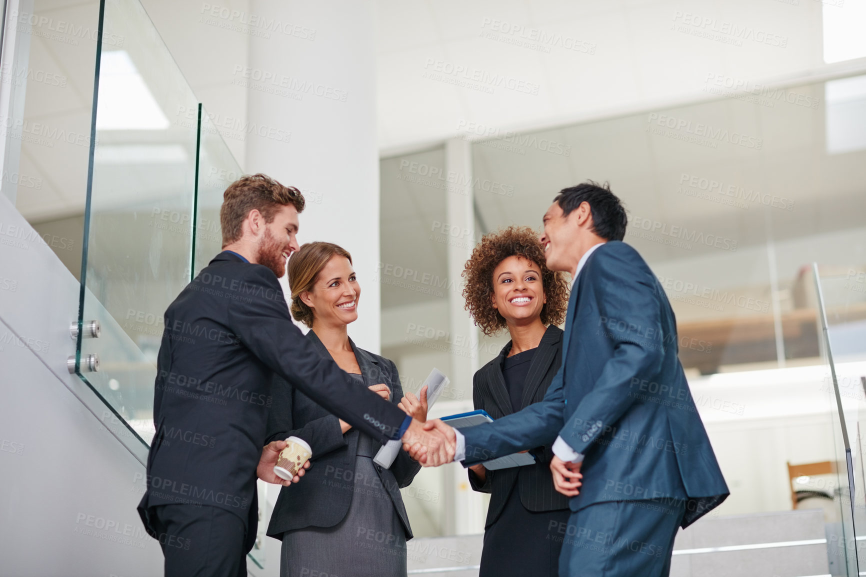 Buy stock photo Cropped shot of businesspeople shaking hands in a modern office