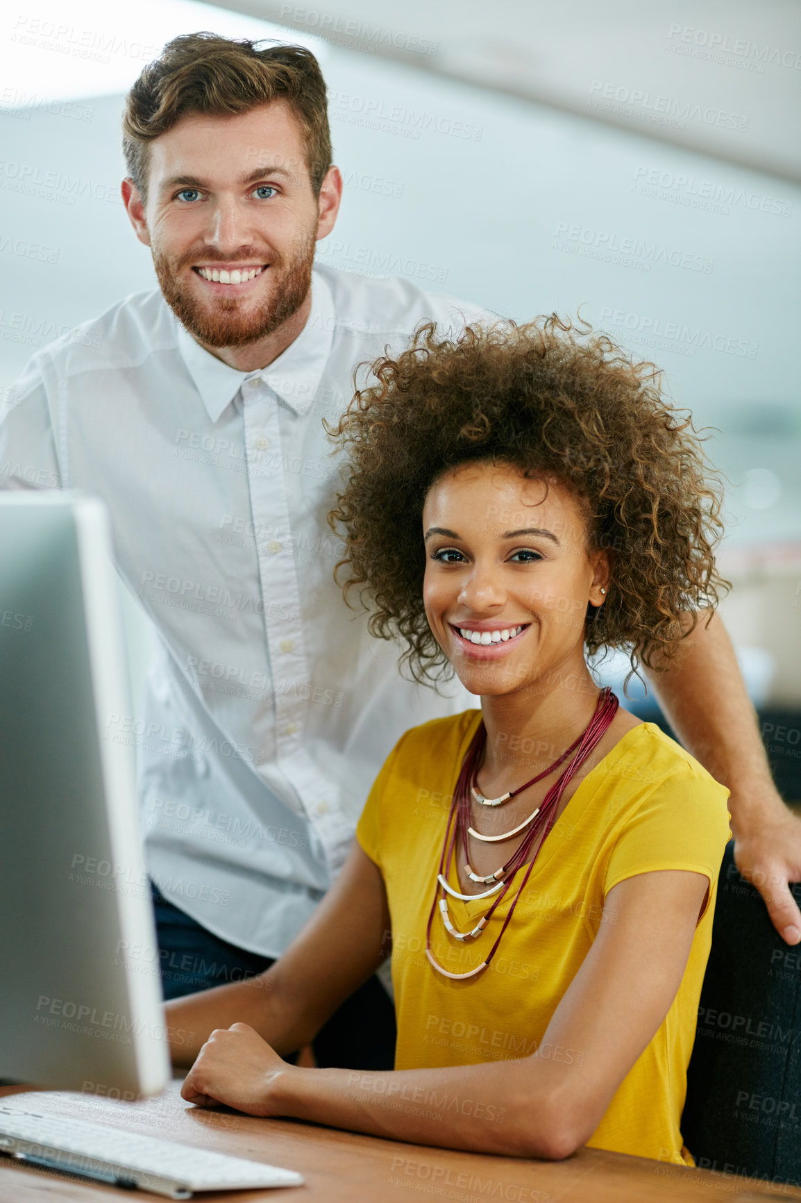 Buy stock photo Shot of a businesswoman and her male colleague looking at something on a computer screen together