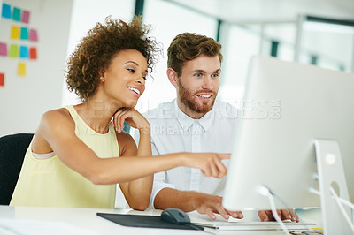 Buy stock photo Shot of a businesswoman and her male colleague looking at something on a computer screen together