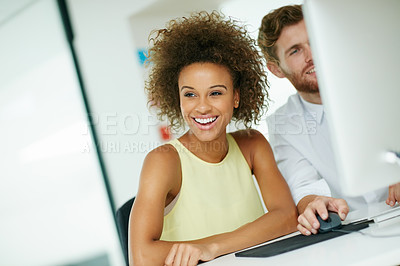 Buy stock photo Shot of a businesswoman and her male colleague looking at something on a computer screen together