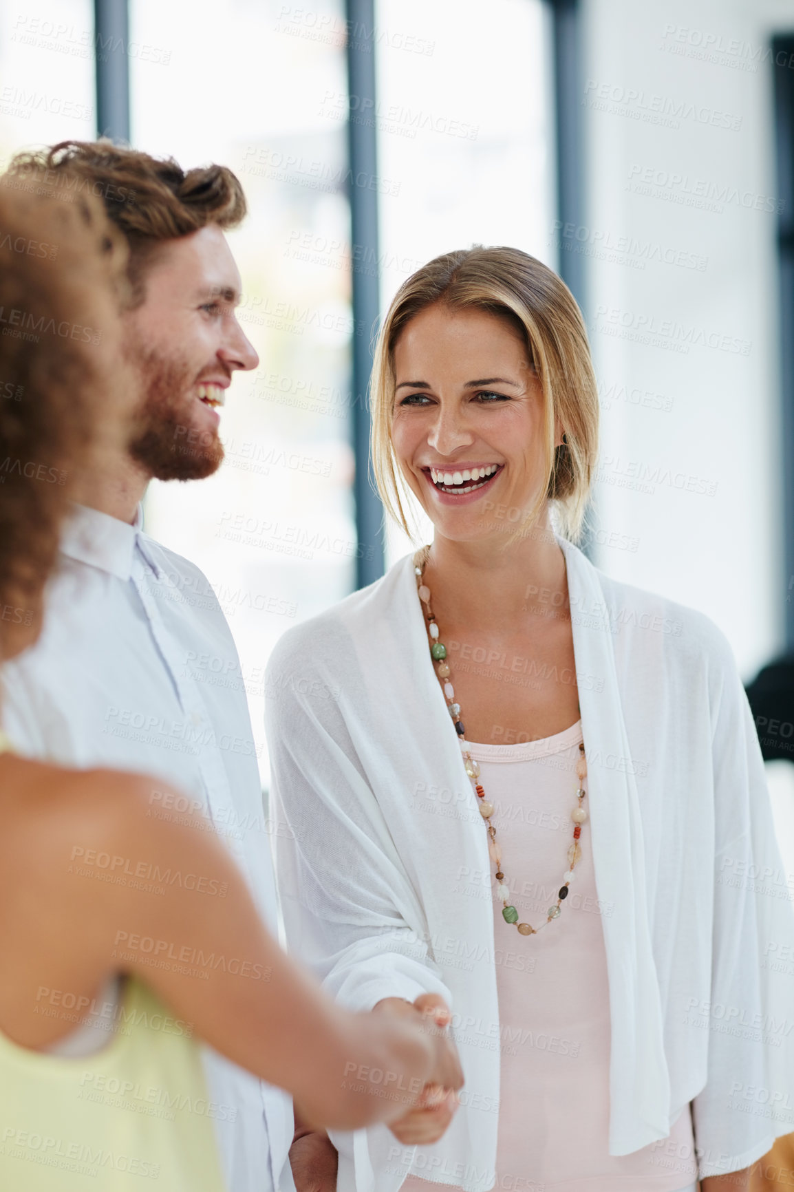 Buy stock photo Shot of a group of businesspeople congratulating their colleague on a promotion by shaking her hand