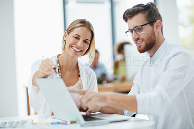 Buy stock photo Shot of a businesswoman and her male colleague working together on a laptop in their office