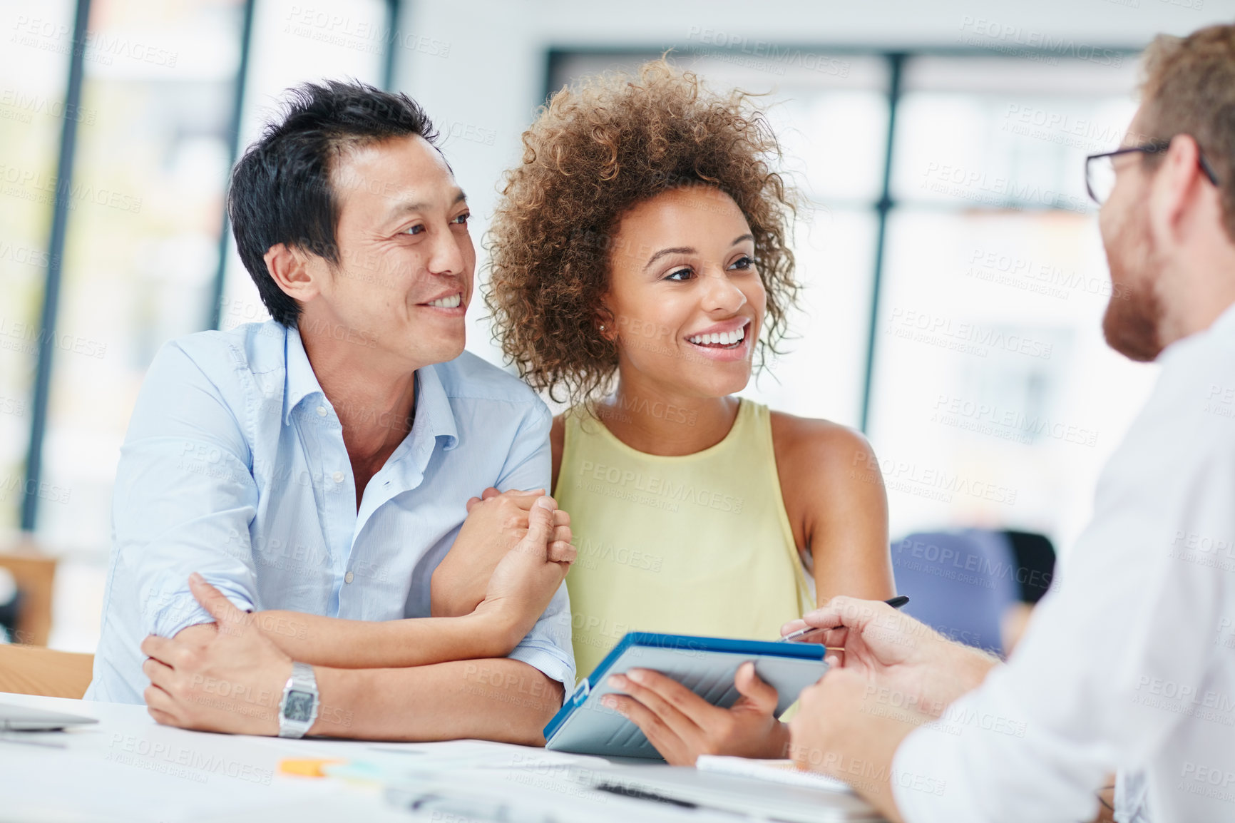 Buy stock photo Shot of a young couple meeting with their advisor in his office