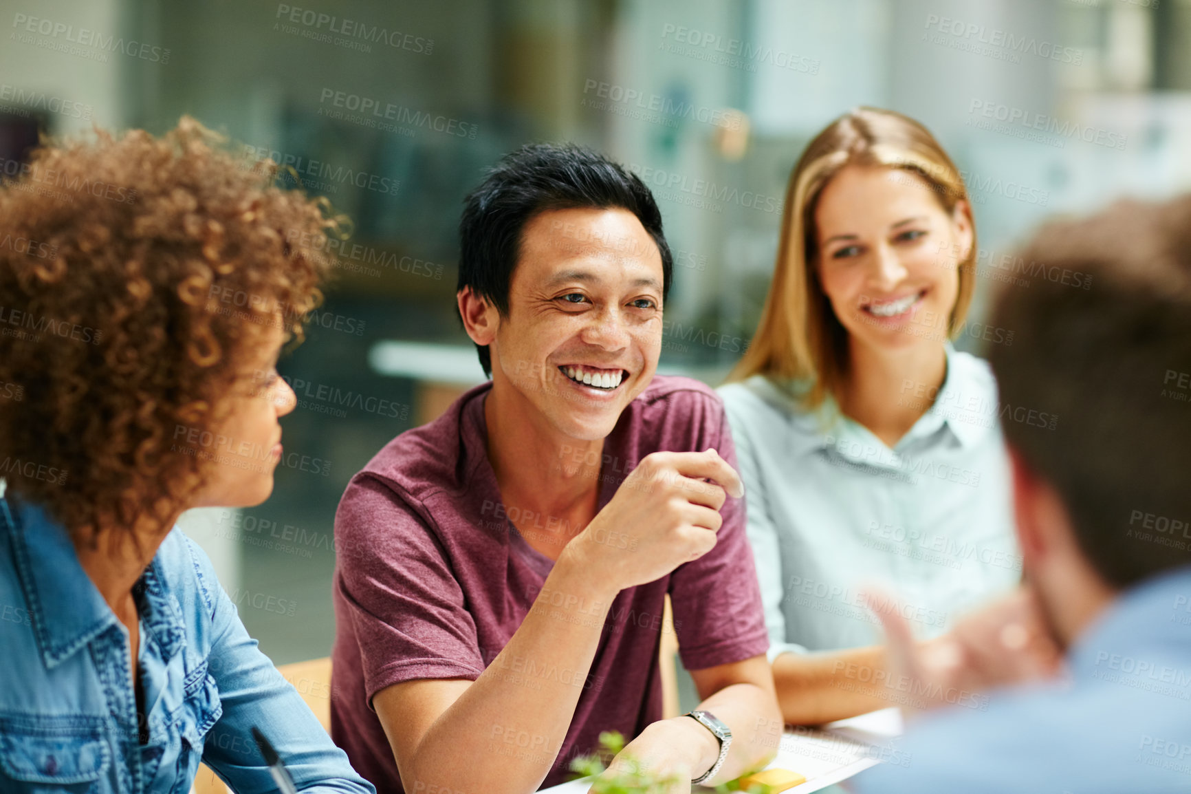 Buy stock photo Shot of a group of smiling businesspeople talking together around a table in an office